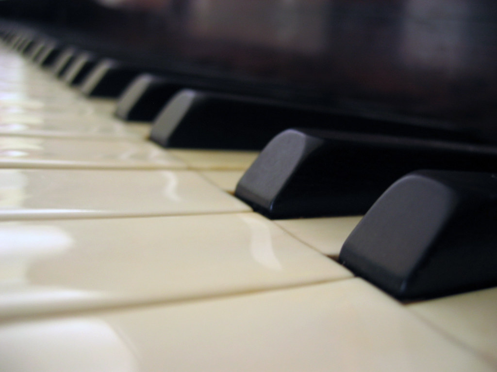Close‑up of black and white piano keys viewed along the keyboard.