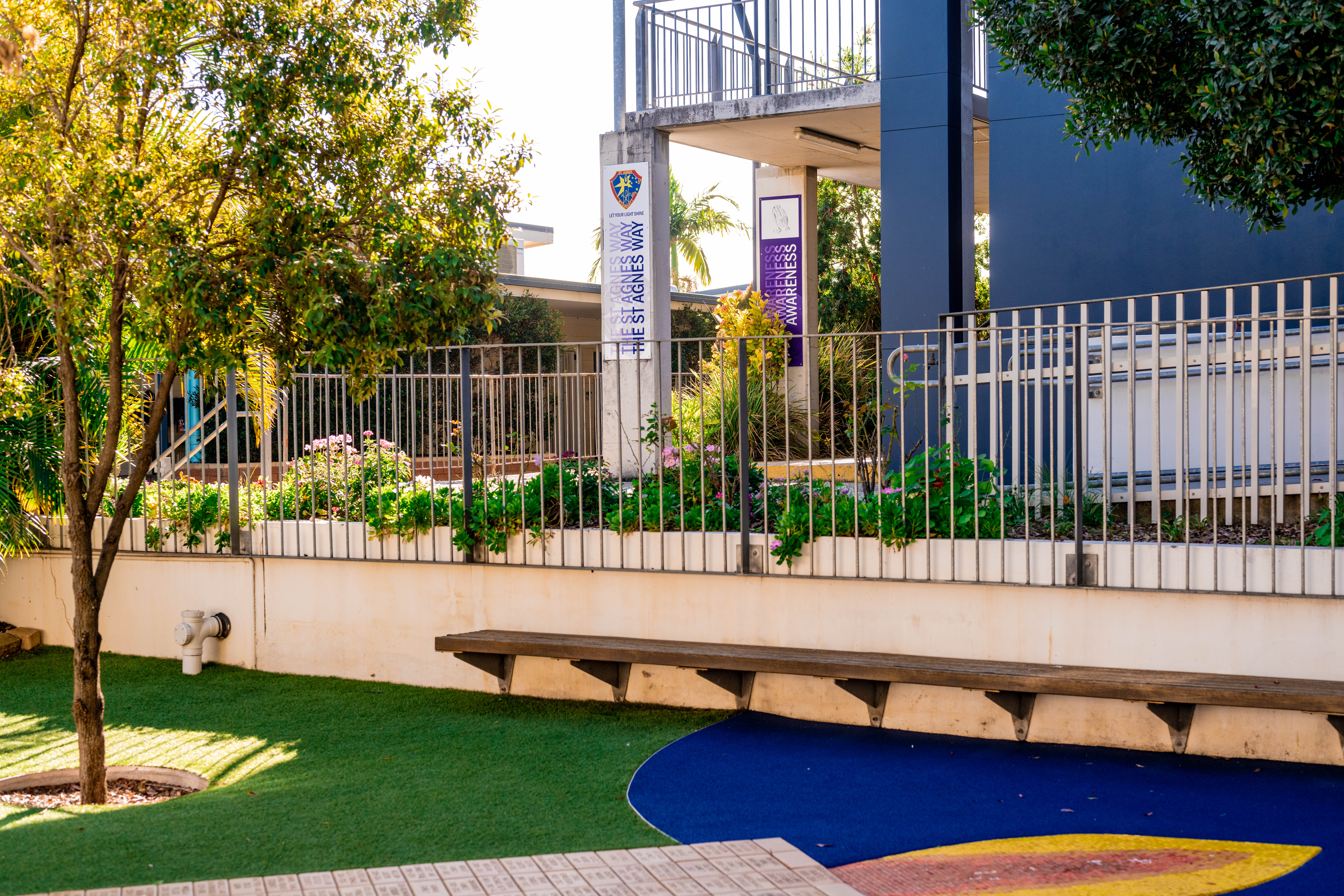 School courtyard with garden beds and Agnes Way signage.